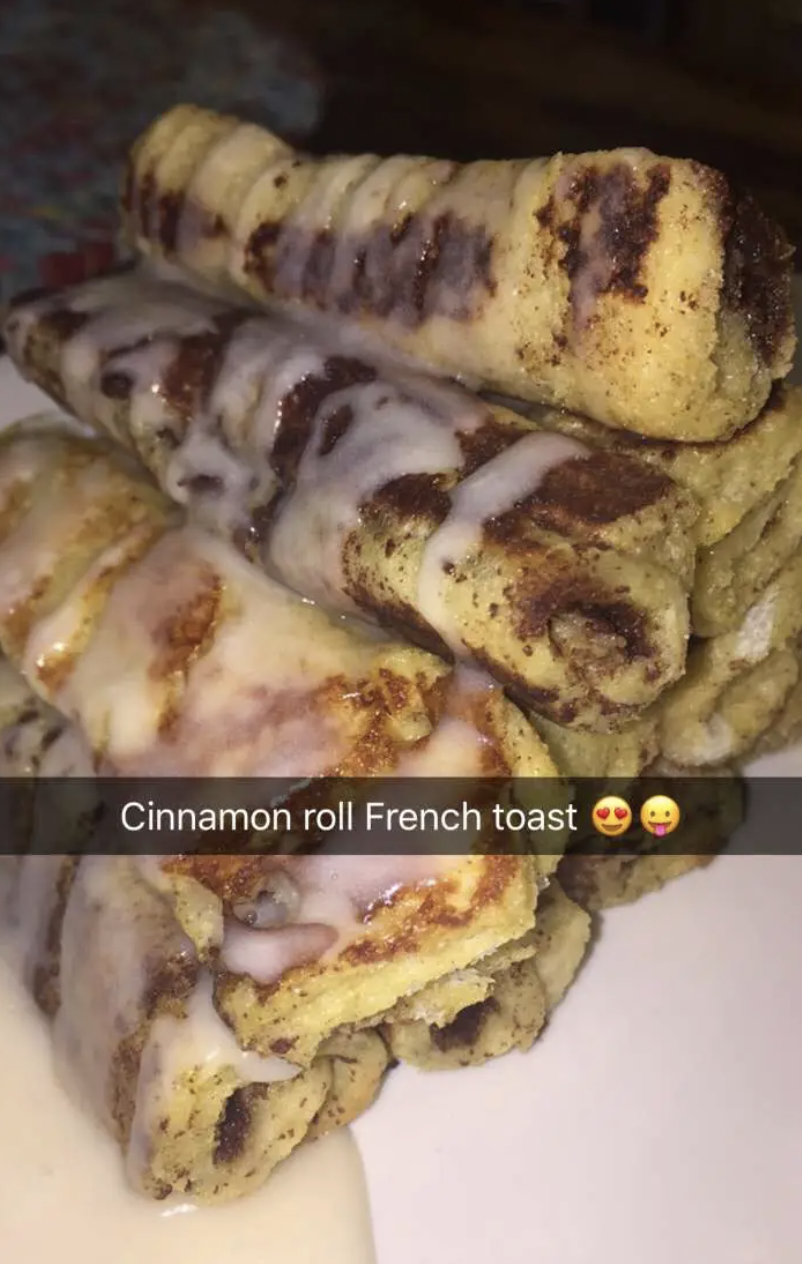 Stack of cinnamon roll French toast drizzled with icing. Text overlay reads, &quot;Cinnamon roll French toast&quot; with heart-eyed and tongue out emojis